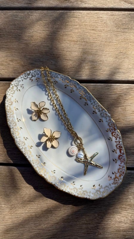 Bijoux dorés présentés sur une coupelle en porcelaine