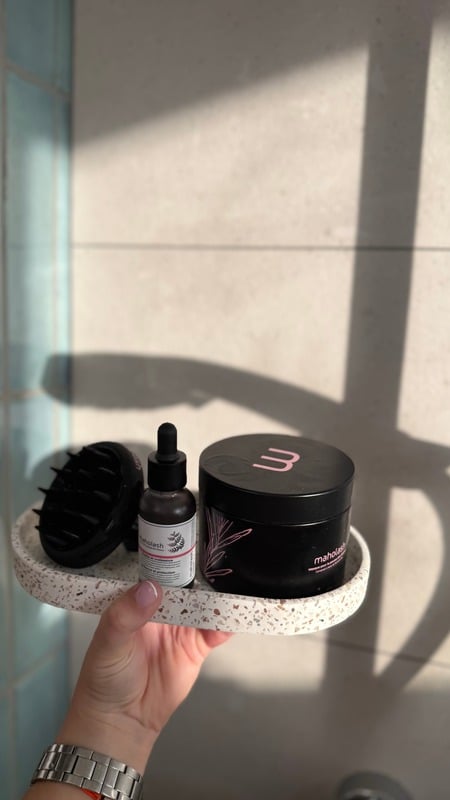 Routine cheveux présentée sur un plateau en terrazzo